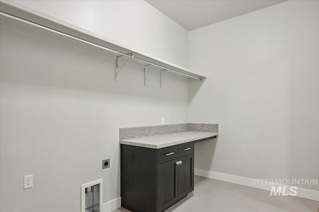 laundry area with light tile patterned flooring, baseboards, laundry area, and hookup for an electric dryer