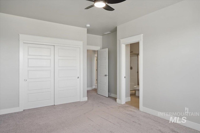 unfurnished bedroom with a closet, carpet floors, baseboards, ensuite bath, and visible vents