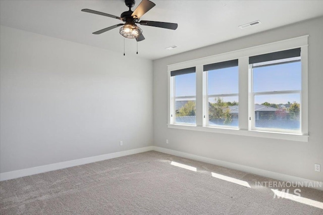 unfurnished room with ceiling fan, baseboards, visible vents, and light carpet