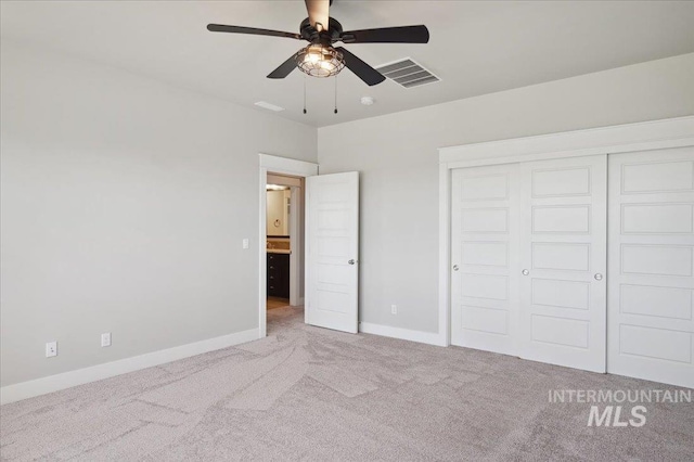 unfurnished bedroom featuring baseboards, visible vents, carpet, and a closet