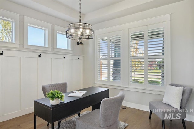 office space featuring baseboards, a notable chandelier, wood finished floors, and plenty of natural light