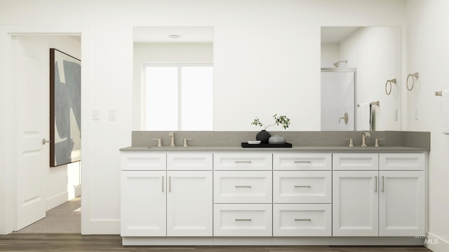 full bath with double vanity, a stall shower, and a sink