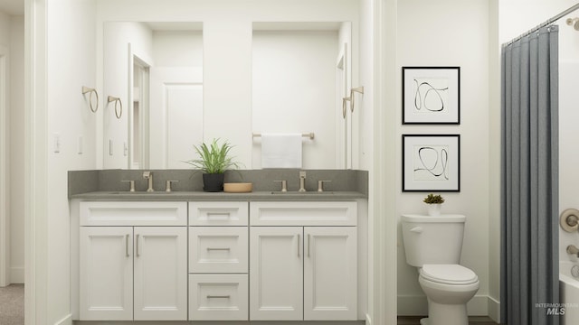 bathroom with toilet, baseboards, double vanity, and a sink