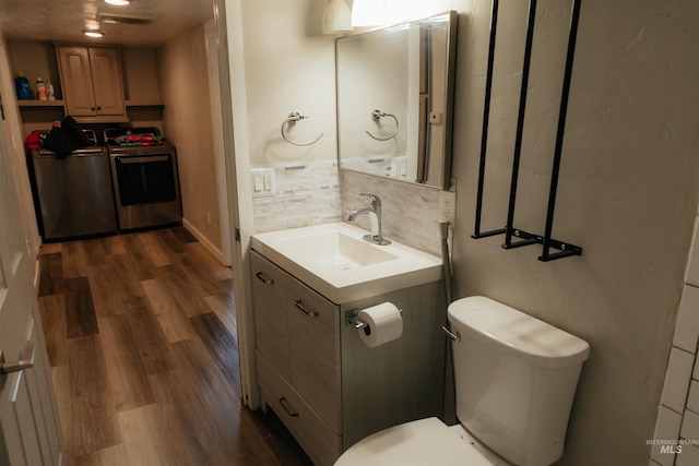 85 E Central Blvd, Cambridge, ID 83610 - half bath with washer / dryer, wood finished floors, toilet, and backsplash