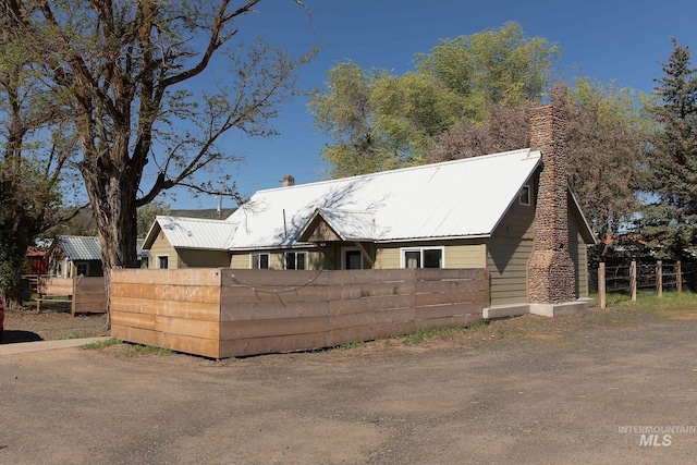 85 E Central Blvd, Cambridge, ID 83610 - view of front facade featuring fence, a chimney, and metal roof