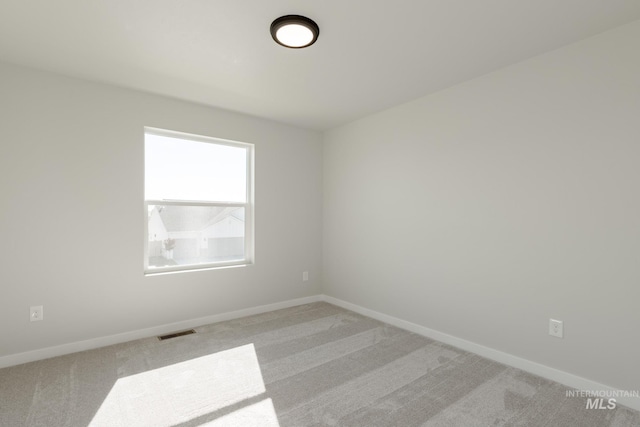 unfurnished room featuring baseboards, visible vents, and carpet floors