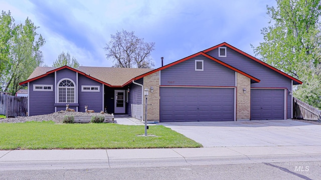view of front of property featuring a garage, fence, driveway, and a front yard