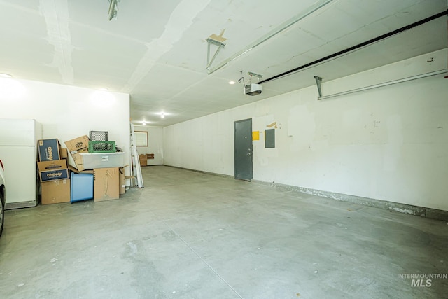 garage with a garage door opener, electric panel, and freestanding refrigerator