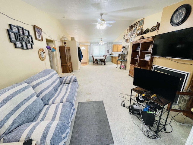 living room with ceiling fan, vaulted ceiling, and light carpet