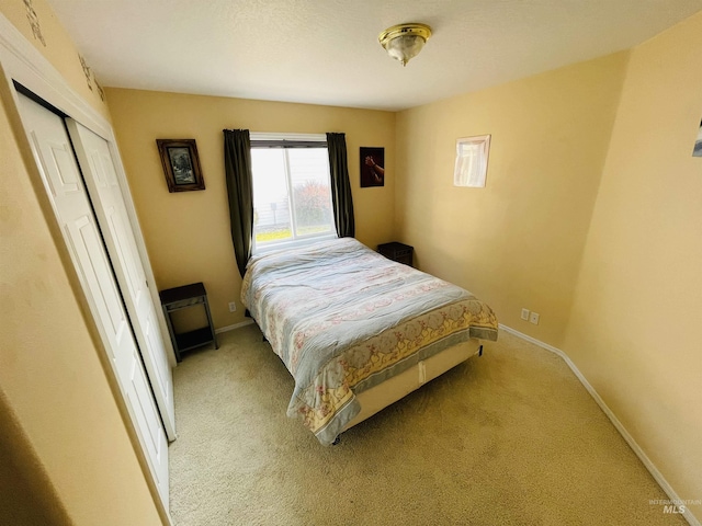 bedroom featuring light colored carpet and a closet