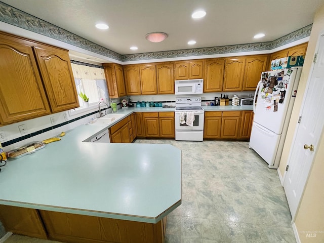 kitchen featuring sink, white appliances, and kitchen peninsula