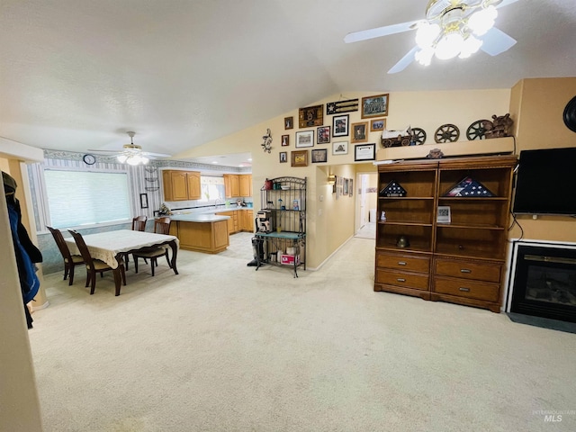 carpeted living room with lofted ceiling and ceiling fan