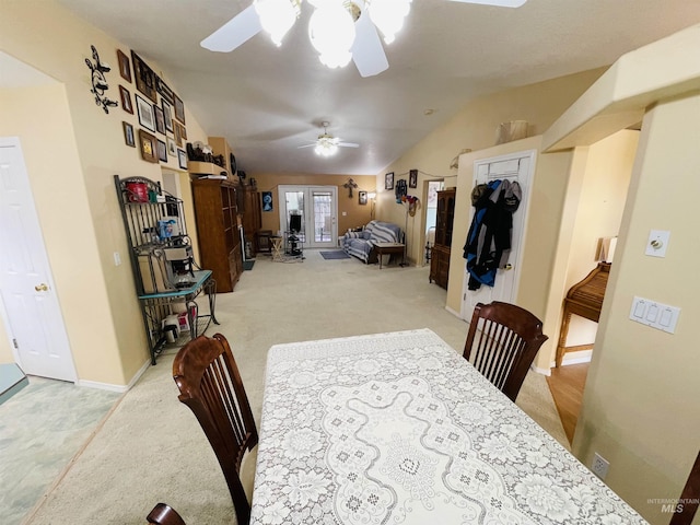 dining room featuring lofted ceiling, light carpet, and ceiling fan