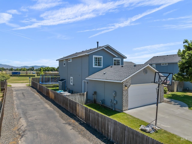 5174 N Rothmans Ave, Boise, ID 83713 - view of front of house with driveway, a mountain view, an attached garage, and roof with shingles