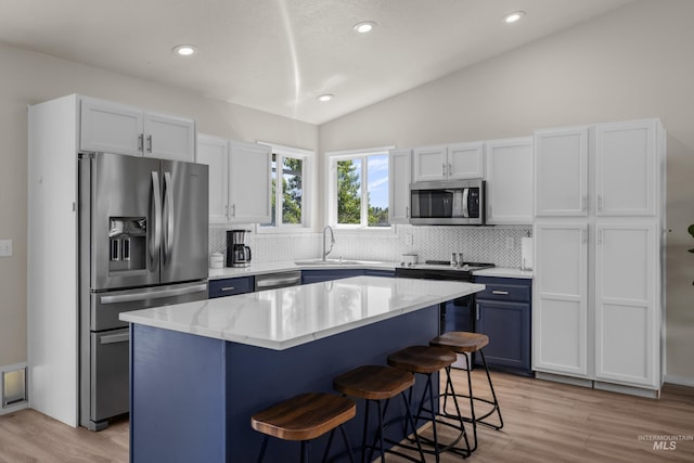 5174 N Rothmans Ave, Boise, ID 83713 - kitchen featuring appliances with stainless steel finishes, lofted ceiling, backsplash, a center island, and a kitchen breakfast bar