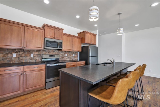 503 April Ave, Twin Falls, ID 83301 - kitchen with appliances with stainless steel finishes, dark countertops, backsplash, a sink, and wood finished floors