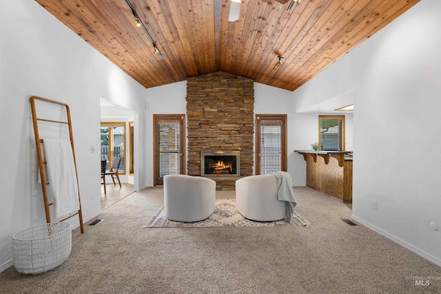 unfurnished living room featuring rail lighting, visible vents, wooden ceiling, baseboards, and a fireplace
