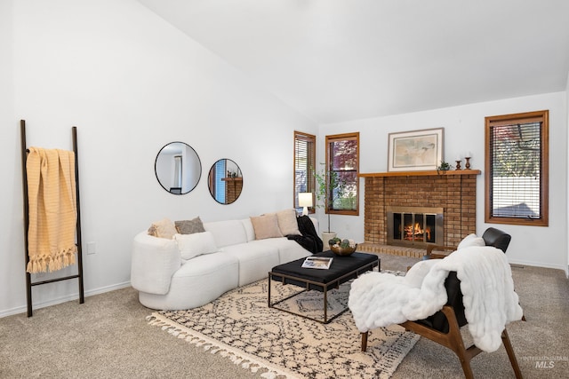 carpeted living area with lofted ceiling, a healthy amount of sunlight, a brick fireplace, and baseboards