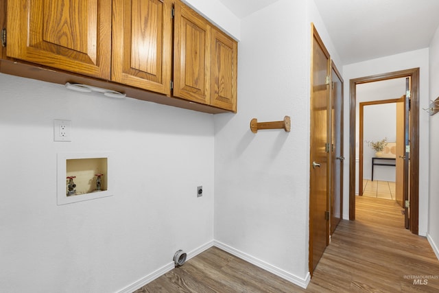 laundry area with hookup for an electric dryer, baseboards, hookup for a washing machine, wood finished floors, and cabinet space