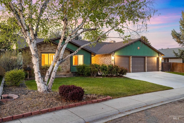 ranch-style home featuring driveway, fence, brick siding, an attached garage, and a lawn