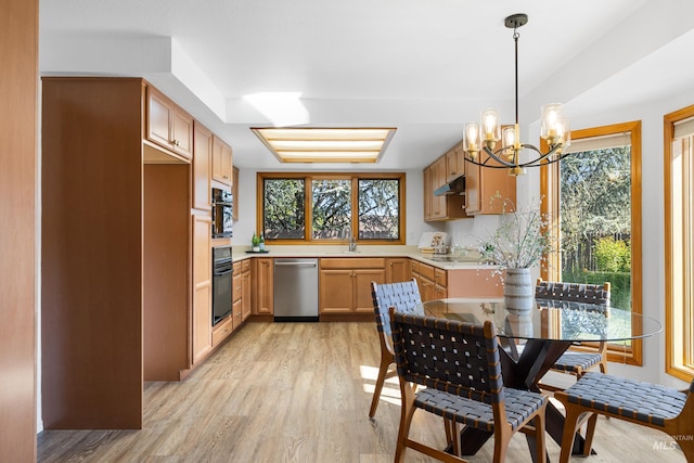 kitchen with oven, light countertops, stainless steel dishwasher, light wood-type flooring, and a chandelier
