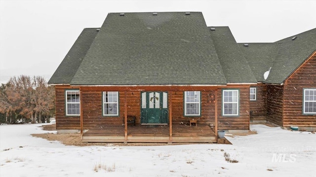 snow covered property featuring roof with shingles and a wooden deck