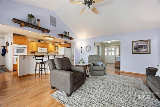 living room with visible vents, baseboards, ceiling fan, light wood-type flooring, and high vaulted ceiling