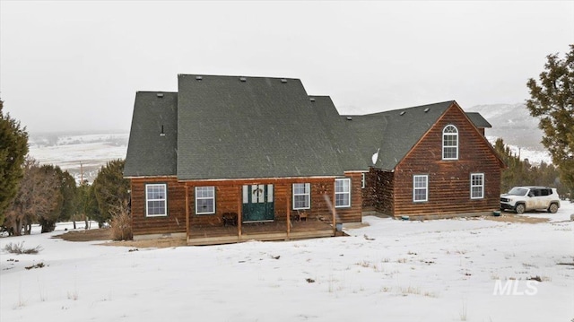 view of snow covered rear of property