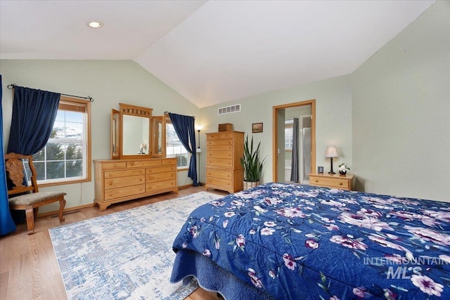 bedroom featuring visible vents, vaulted ceiling, and wood finished floors