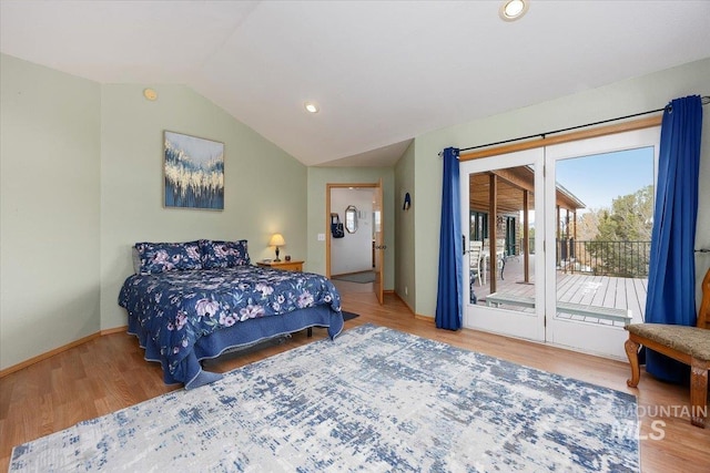 bedroom featuring access to outside, baseboards, vaulted ceiling, and wood finished floors