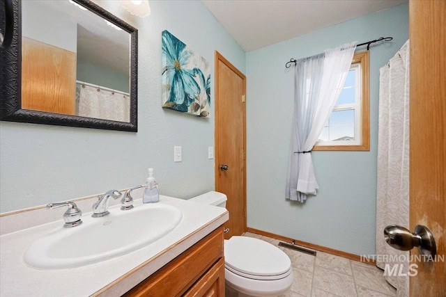 bathroom with toilet, vanity, visible vents, and baseboards