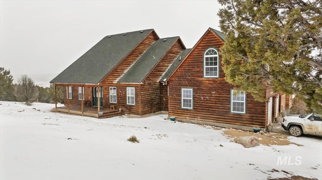 view of snow covered back of property