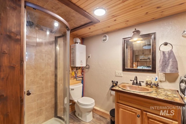 bathroom with vanity, wood finished floors, toilet, a shower stall, and tankless water heater