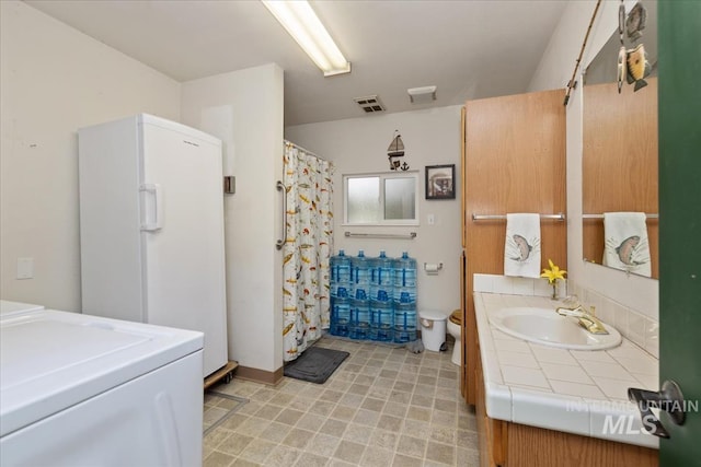 bathroom featuring visible vents, washing machine and dryer, vanity, toilet, and a shower with shower curtain