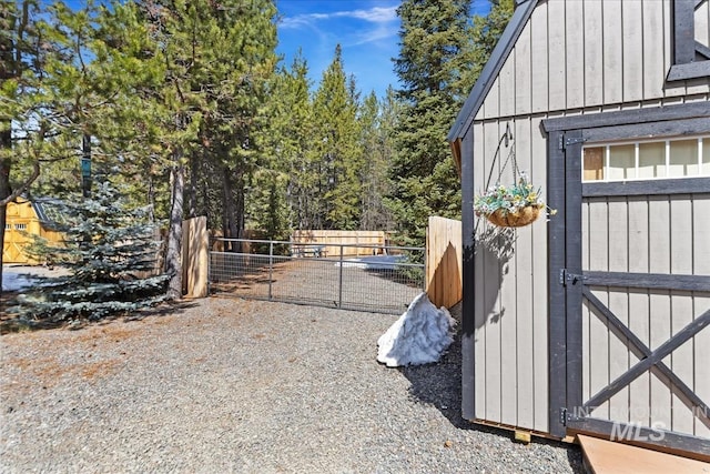 exterior space featuring fence, an outbuilding, and a shed