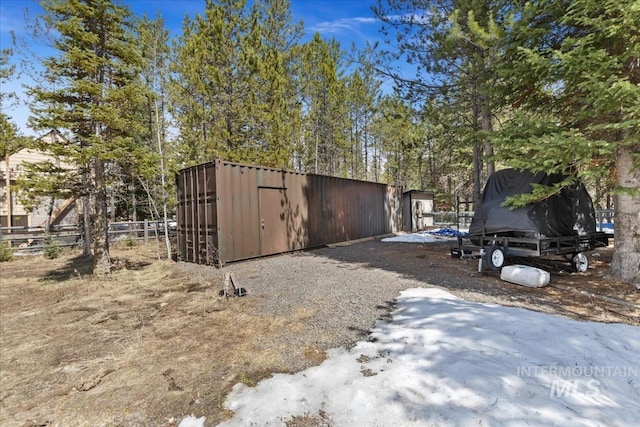 view of outdoor structure featuring fence and an outbuilding