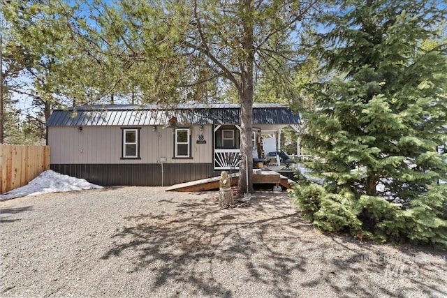 manufactured / mobile home featuring fence and metal roof