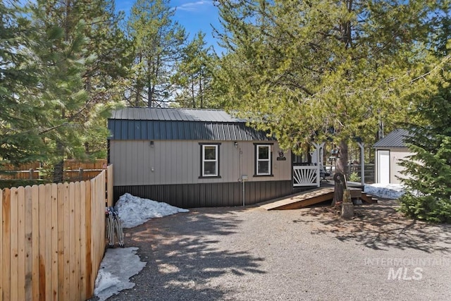 view of front facade featuring fence and an outbuilding