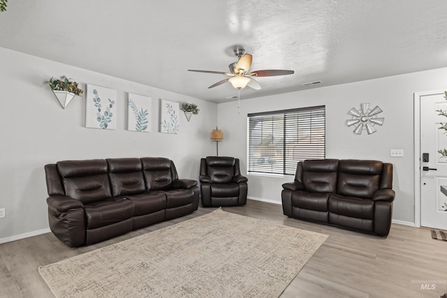 living room featuring wood finished floors, baseboards, and ceiling fan