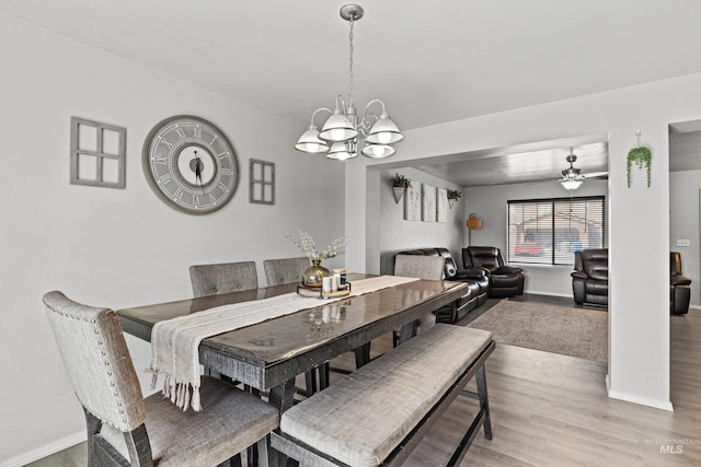 dining area featuring baseboards, a chandelier, light wood-type flooring, and a ceiling fan