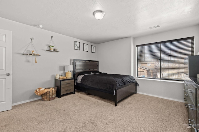 carpeted bedroom with baseboards and a textured ceiling