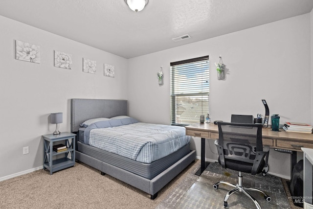 carpeted bedroom featuring an office area, baseboards, and a textured ceiling