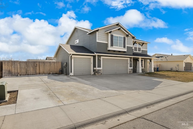 view of front of house with fence, driveway, an attached garage, stone siding, and a garage