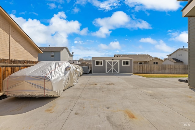 view of patio with a storage unit, an outdoor structure, and a fenced backyard