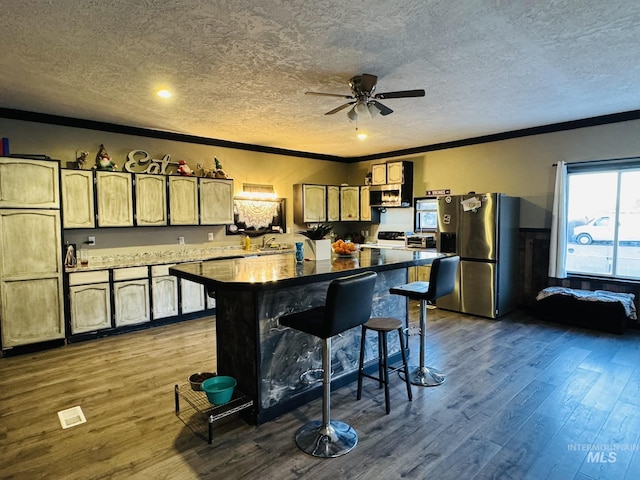 kitchen featuring a textured ceiling, stainless steel refrigerator with ice dispenser, dark wood finished floors, and crown molding