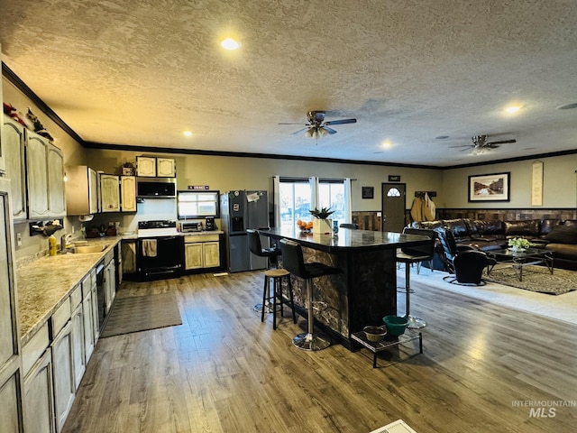 kitchen with crown molding, stainless steel microwave, electric range, a sink, and refrigerator with ice dispenser