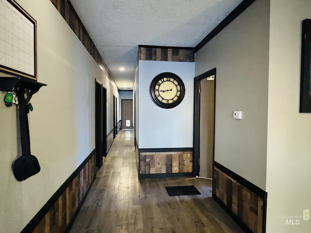 corridor featuring a textured ceiling and wood finished floors