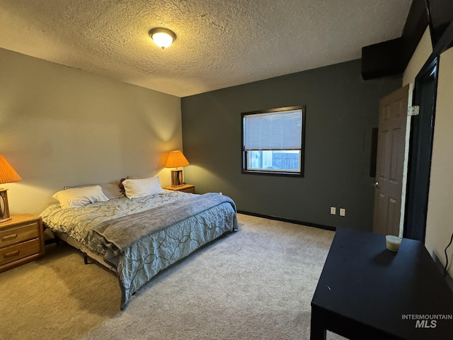 carpeted bedroom featuring baseboards and a textured ceiling