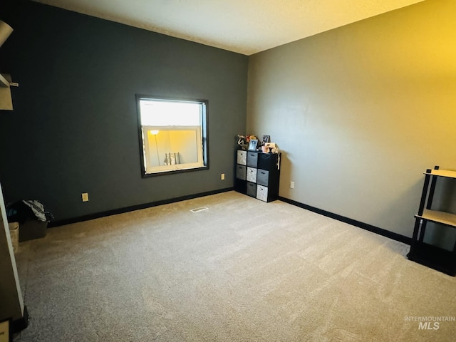 empty room featuring baseboards and carpet flooring