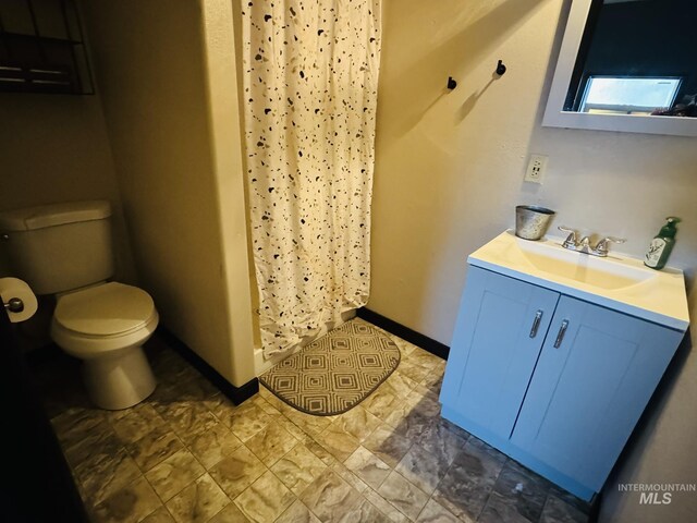 bathroom with baseboards, vanity, toilet, and a shower with curtain